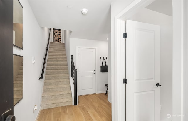 stairway with light hardwood / wood-style floors