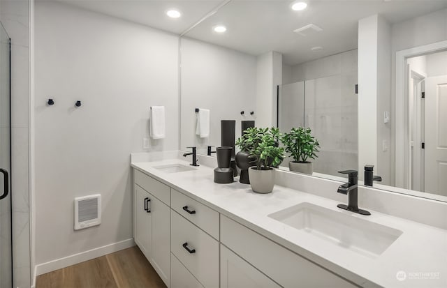 bathroom featuring double sink vanity, hardwood / wood-style flooring, and walk in shower