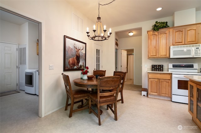 dining room featuring washer / dryer and an inviting chandelier