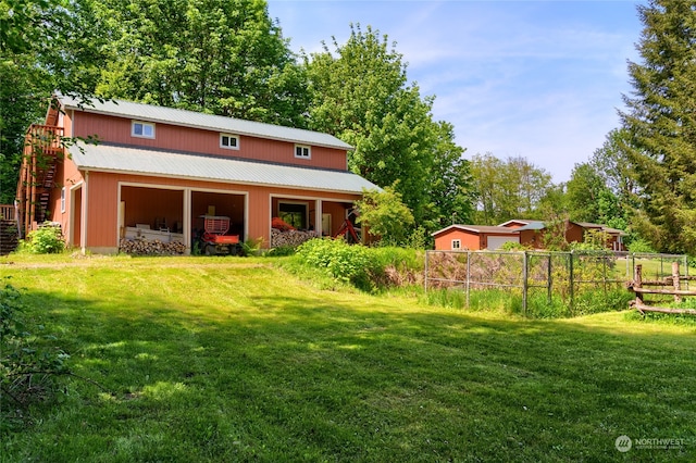 back of house with a yard and an outdoor structure