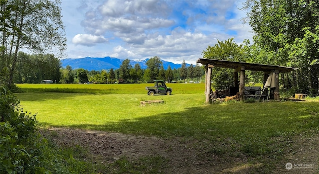 surrounding community with a lawn and a mountain view