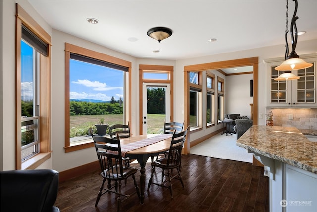 dining space featuring ornamental molding, dark wood-type flooring, and plenty of natural light