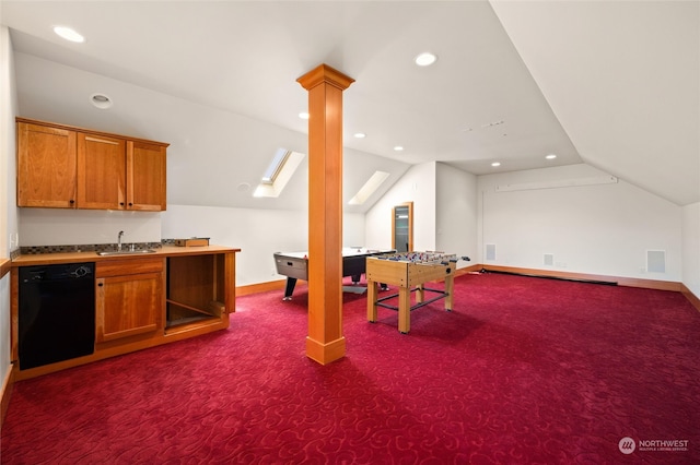 kitchen featuring carpet floors, decorative columns, dishwasher, vaulted ceiling, and sink