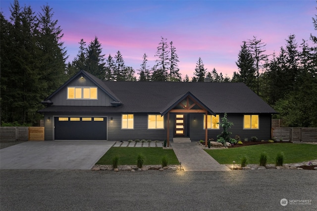 modern inspired farmhouse featuring a garage and a lawn