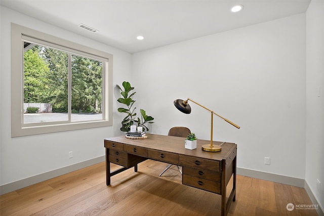 office space with a healthy amount of sunlight and light hardwood / wood-style flooring