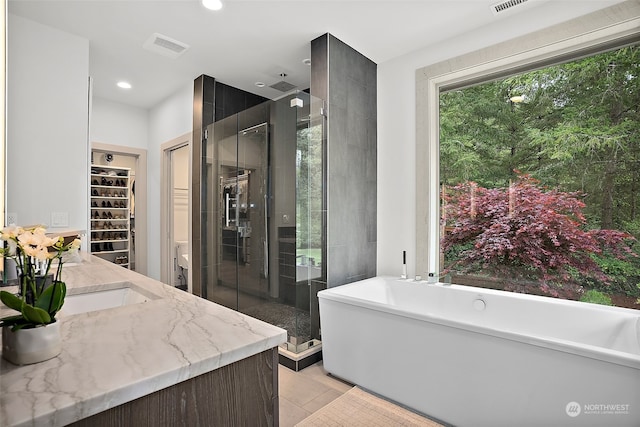 bathroom with tile floors, sink, and plus walk in shower