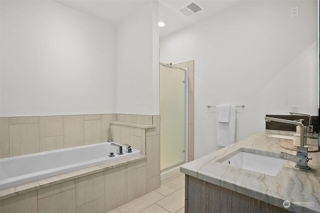 bathroom with tile floors, shower with separate bathtub, and vanity