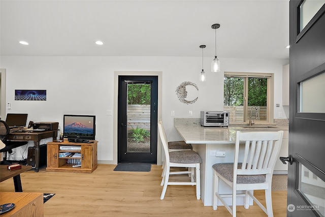 dining space with sink, plenty of natural light, and light wood-type flooring