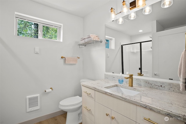 bathroom with wood-type flooring, oversized vanity, and toilet