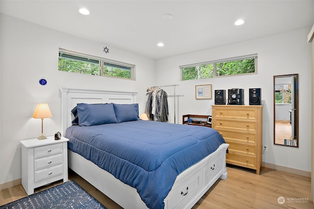 bedroom featuring multiple windows and light hardwood / wood-style flooring