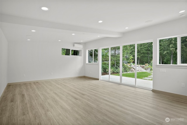 empty room featuring light hardwood / wood-style floors and a wall unit AC