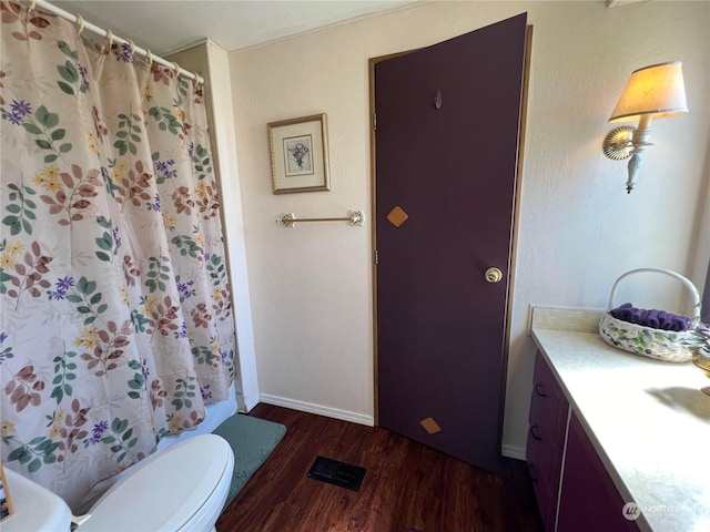 bathroom with vanity, wood-type flooring, toilet, and walk in shower