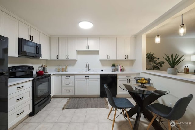 kitchen with pendant lighting, black appliances, light tile floors, sink, and white cabinetry