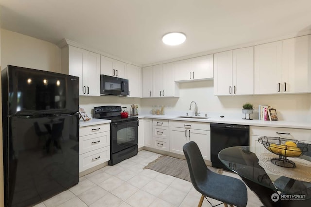 kitchen featuring white cabinetry, sink, and black appliances