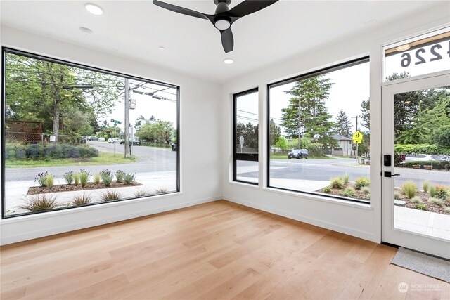 unfurnished sunroom with ceiling fan