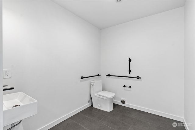 bathroom featuring tile flooring, sink, and toilet