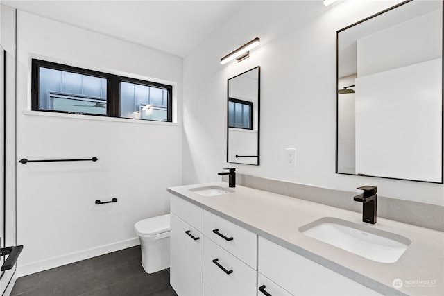 bathroom with tile floors, toilet, and dual bowl vanity