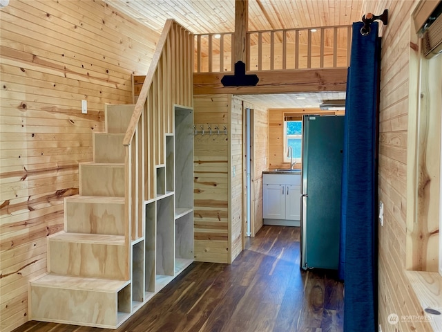 stairway with wood walls, wooden ceiling, sink, and dark hardwood / wood-style floors