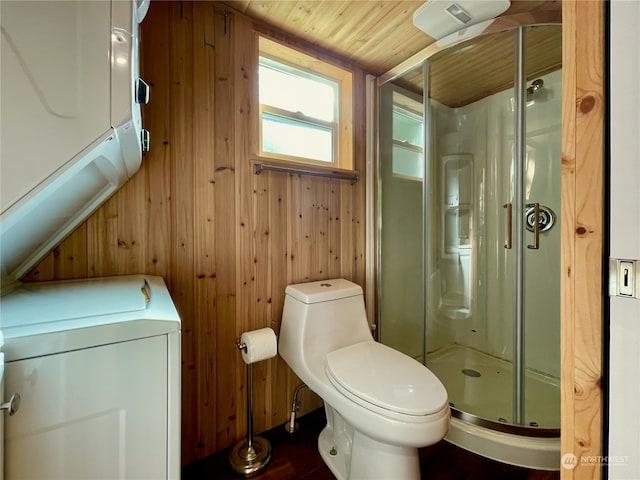 bathroom featuring washer / clothes dryer, a shower with shower door, wooden ceiling, wooden walls, and toilet