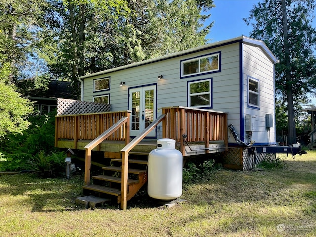 rear view of house featuring a yard, a deck, and french doors