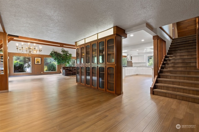 interior space with a healthy amount of sunlight, a notable chandelier, and hardwood / wood-style flooring