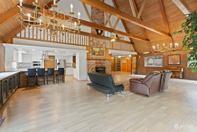 living room featuring high vaulted ceiling, beam ceiling, a fireplace, and wood ceiling