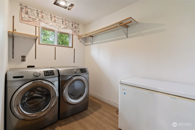 washroom with light hardwood / wood-style flooring and independent washer and dryer