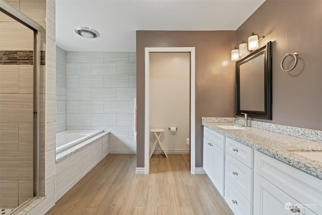 full bathroom featuring hardwood / wood-style flooring, independent shower and bath, toilet, and dual bowl vanity