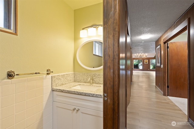 bathroom with a textured ceiling, vanity, and hardwood / wood-style floors