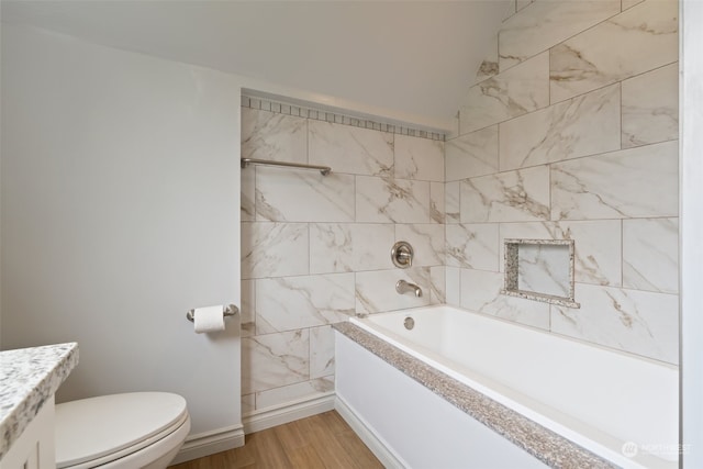 full bathroom with tiled shower / bath, vanity, toilet, and hardwood / wood-style floors