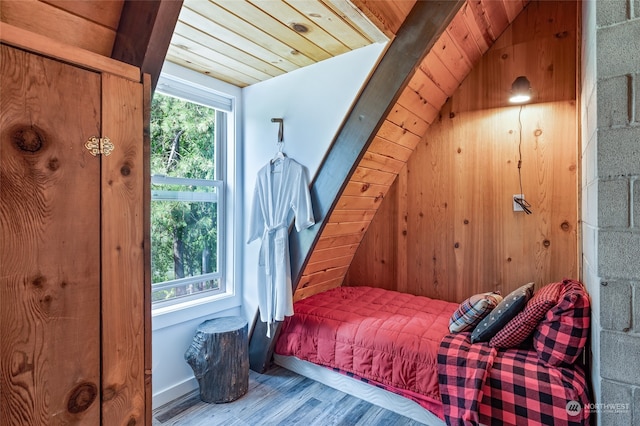 bedroom with wooden ceiling, wood-type flooring, wood walls, and vaulted ceiling