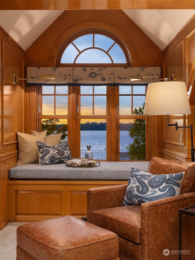 living room featuring a wealth of natural light, lofted ceiling, and a water view