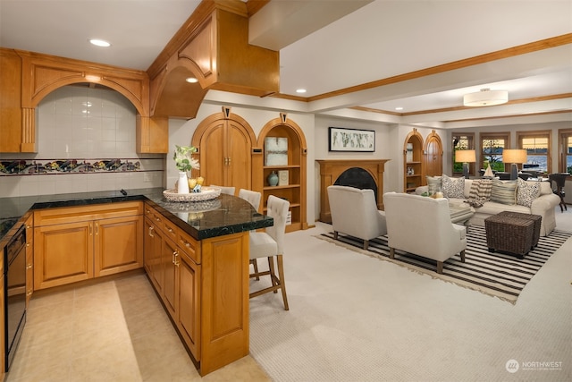 kitchen featuring a breakfast bar, backsplash, and light tile flooring