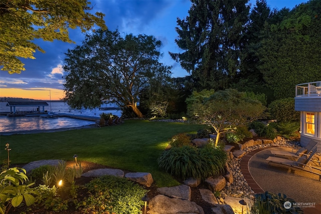 yard at dusk featuring a dock