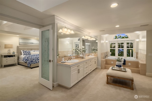 bathroom featuring a relaxing tiled bath, beamed ceiling, oversized vanity, and double sink