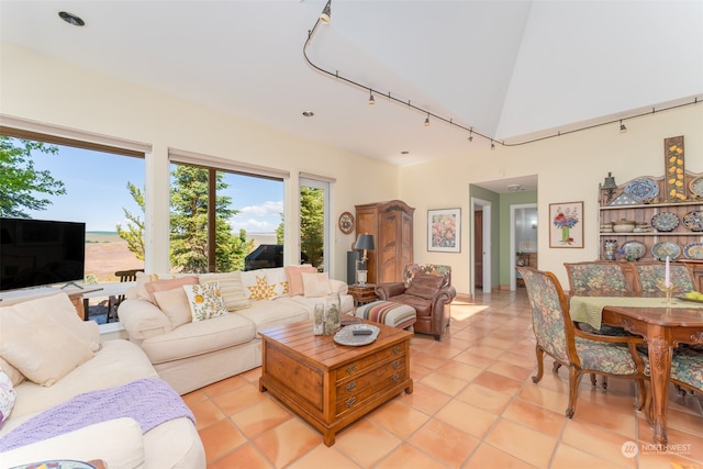 tiled living room featuring high vaulted ceiling and rail lighting