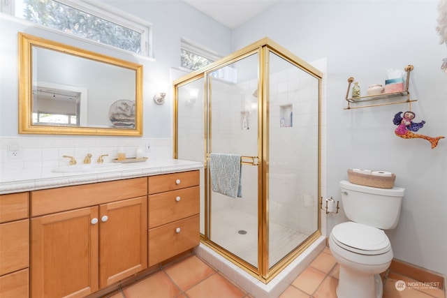 bathroom featuring backsplash, toilet, tile flooring, a shower with door, and vanity