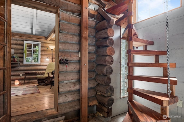 staircase with a healthy amount of sunlight and log walls