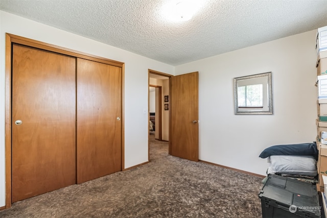 carpeted bedroom with a textured ceiling and a closet