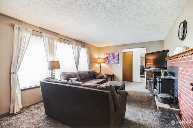 carpeted living room featuring a textured ceiling and a brick fireplace