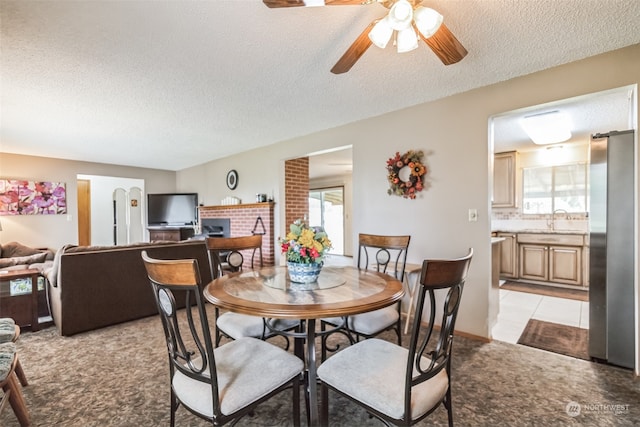 dining space featuring a textured ceiling, plenty of natural light, ceiling fan, and light tile floors