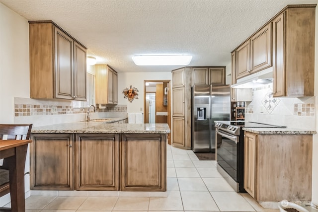 kitchen with backsplash, kitchen peninsula, light tile floors, and stainless steel appliances