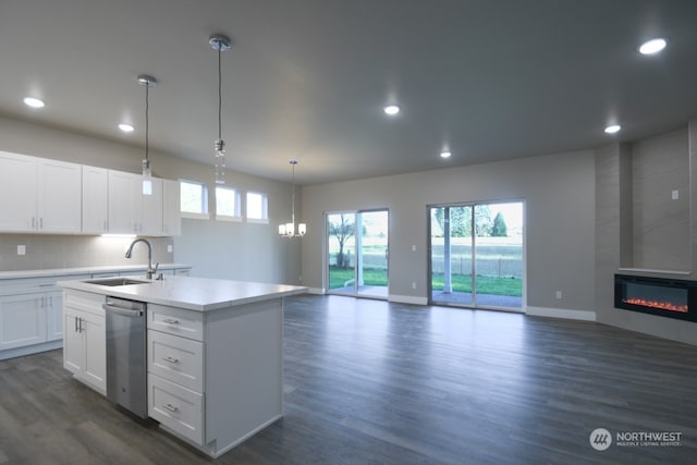 kitchen featuring a fireplace, dishwasher, sink, and white cabinets