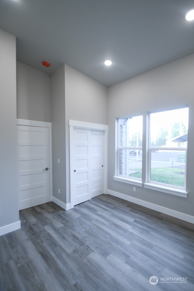 unfurnished bedroom with dark hardwood / wood-style flooring and a closet