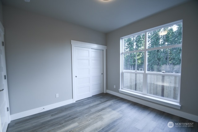 unfurnished bedroom with dark wood-type flooring and a closet