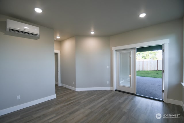 unfurnished room with dark hardwood / wood-style floors and an AC wall unit