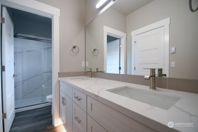 bathroom featuring hardwood / wood-style flooring, vanity, toilet, and walk in shower