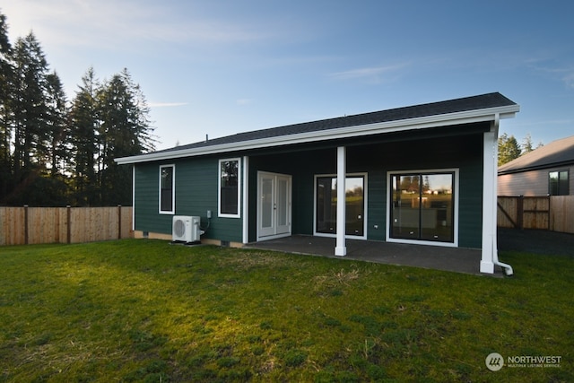 rear view of house with ac unit and a lawn