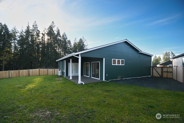 rear view of house featuring a lawn and a patio