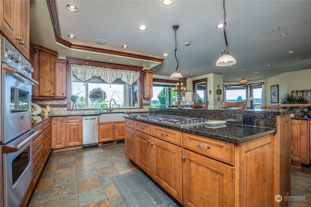 kitchen featuring tile patterned flooring, backsplash, hanging light fixtures, appliances with stainless steel finishes, and sink